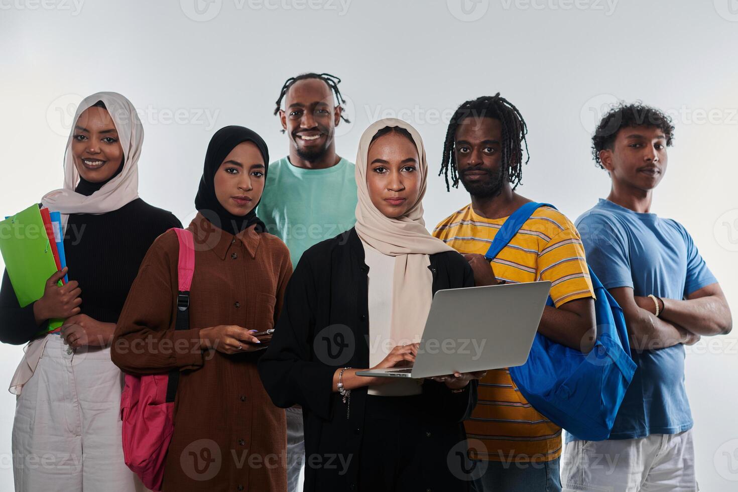 Group of diverse students engages in modern educational practices, utilizing a variety of technological tools such as laptops, tablets, and smartphones against a clean white background, exemplifying photo