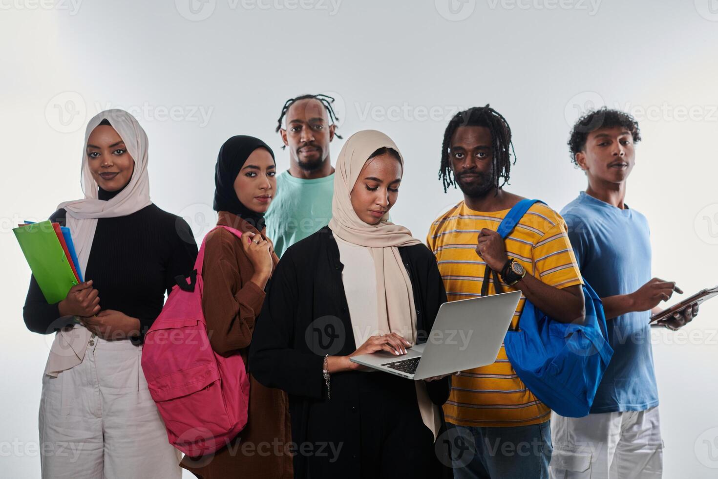 Group of diverse students engages in modern educational practices, utilizing a variety of technological tools such as laptops, tablets, and smartphones against a clean white background, exemplifying photo