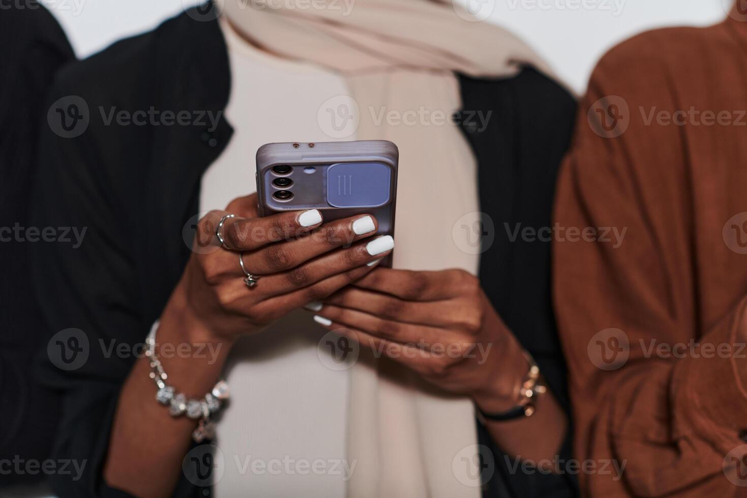 Captured in a close-up moment, a girl in hijab skillfully engages with her smartphone, reflecting a contemporary lifestyle where digital connectivity seamlessly intertwines with cultural expression photo