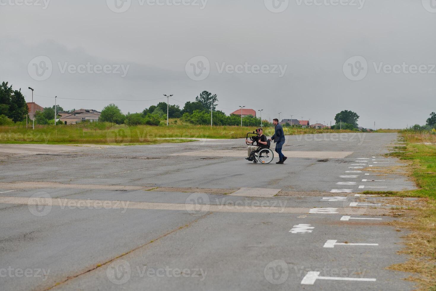 A team of videographers utilizes modern filming equipment while incorporating innovative accessibility tools, including the use of wheelchairs as aids, showcasing a creative and inclusive approach to photo