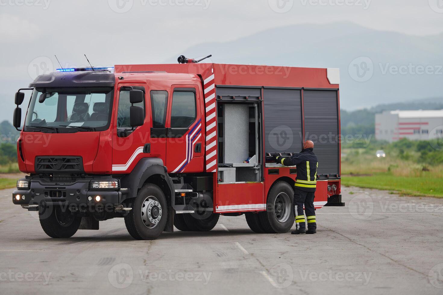 A firefighter meticulously prepares a modern firetruck for a mission to evacuate and respond to dangerous situations, showcasing the utmost dedication to safety and readiness in the face of a fire photo
