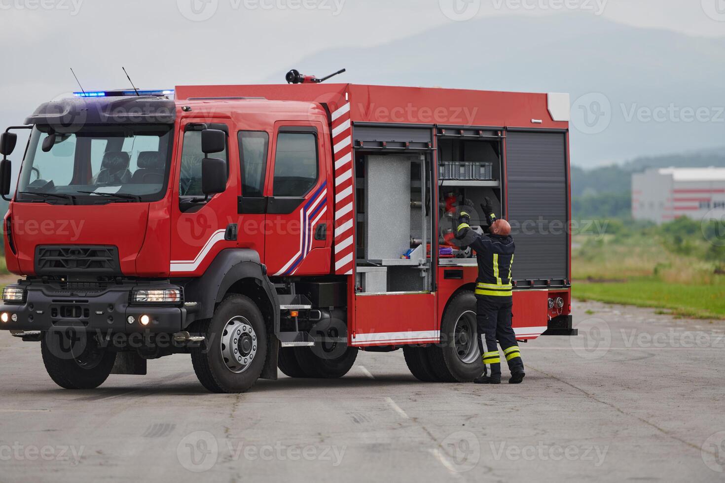 A firefighter meticulously prepares a modern firetruck for a mission to evacuate and respond to dangerous situations, showcasing the utmost dedication to safety and readiness in the face of a fire photo