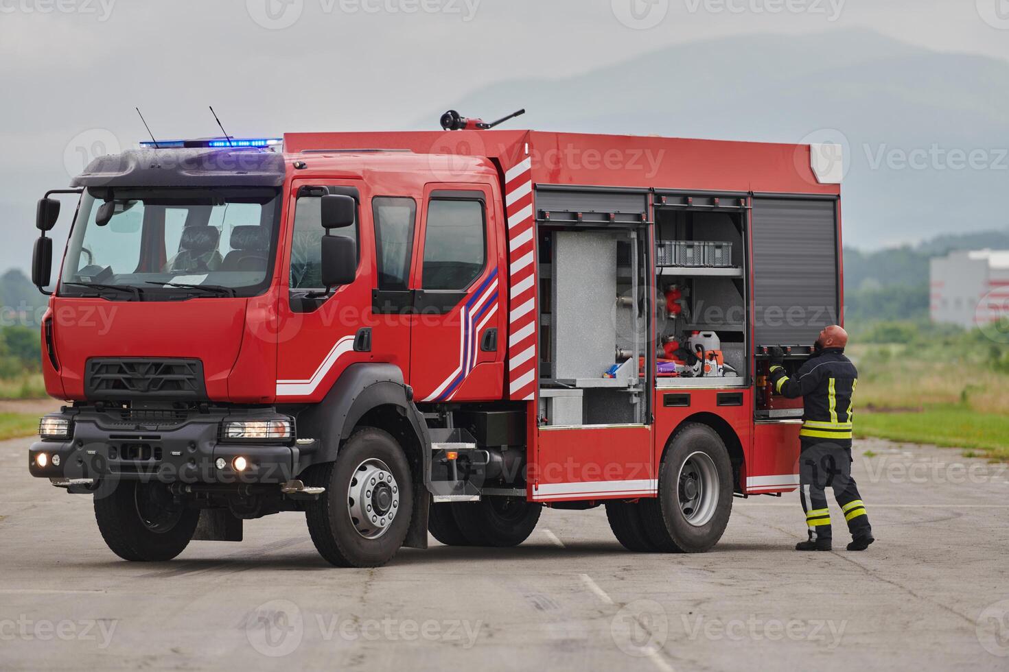 A firefighter meticulously prepares a modern firetruck for a mission to evacuate and respond to dangerous situations, showcasing the utmost dedication to safety and readiness in the face of a fire photo
