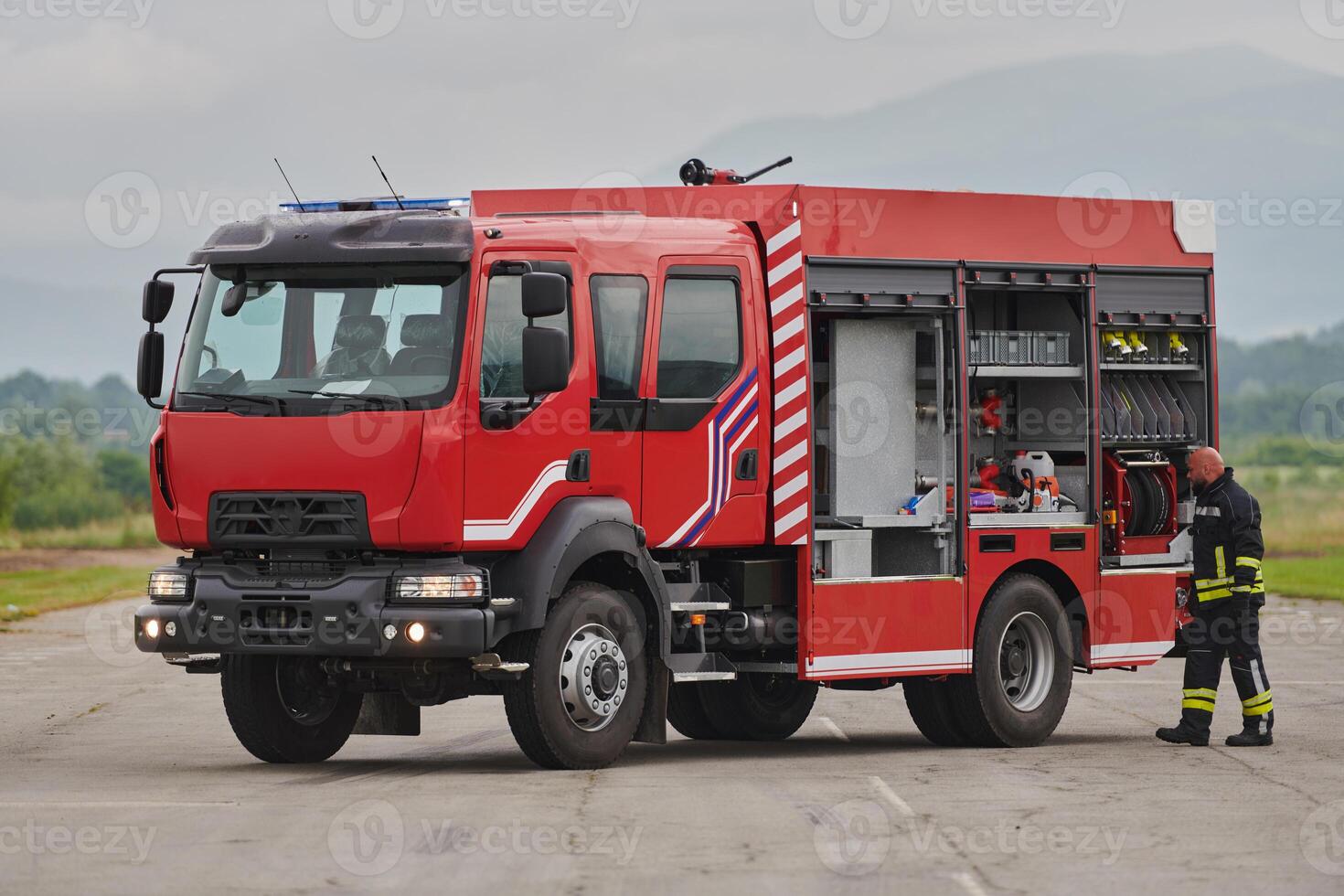 A firefighter meticulously prepares a modern firetruck for a mission to evacuate and respond to dangerous situations, showcasing the utmost dedication to safety and readiness in the face of a fire photo