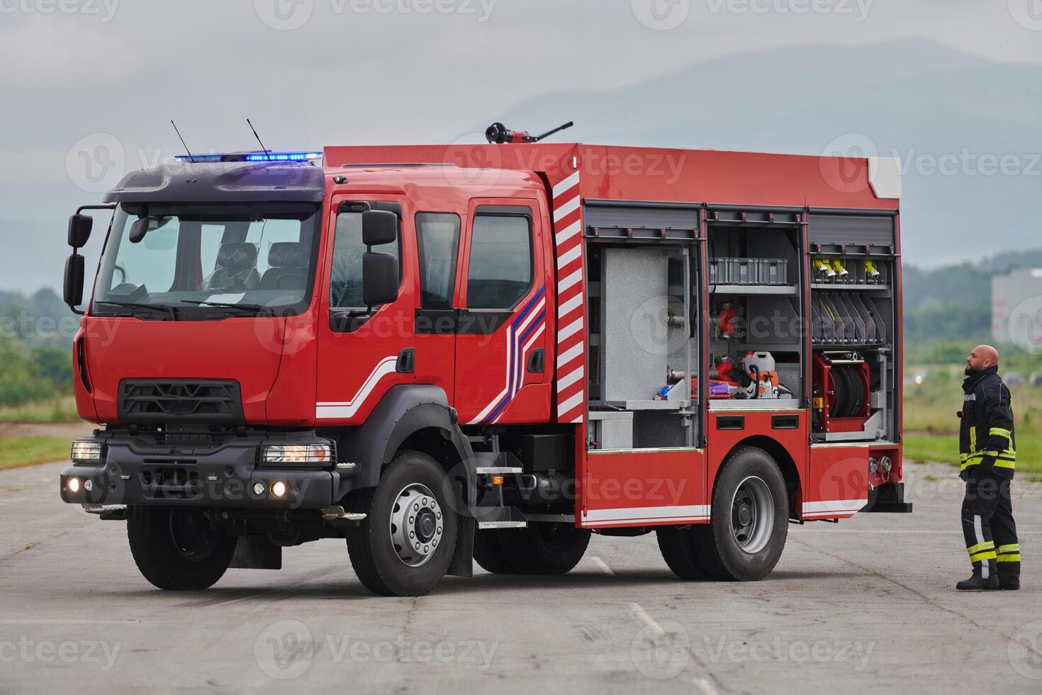 A firefighter meticulously prepares a modern firetruck for a mission to evacuate and respond to dangerous situations, showcasing the utmost dedication to safety and readiness in the face of a fire photo