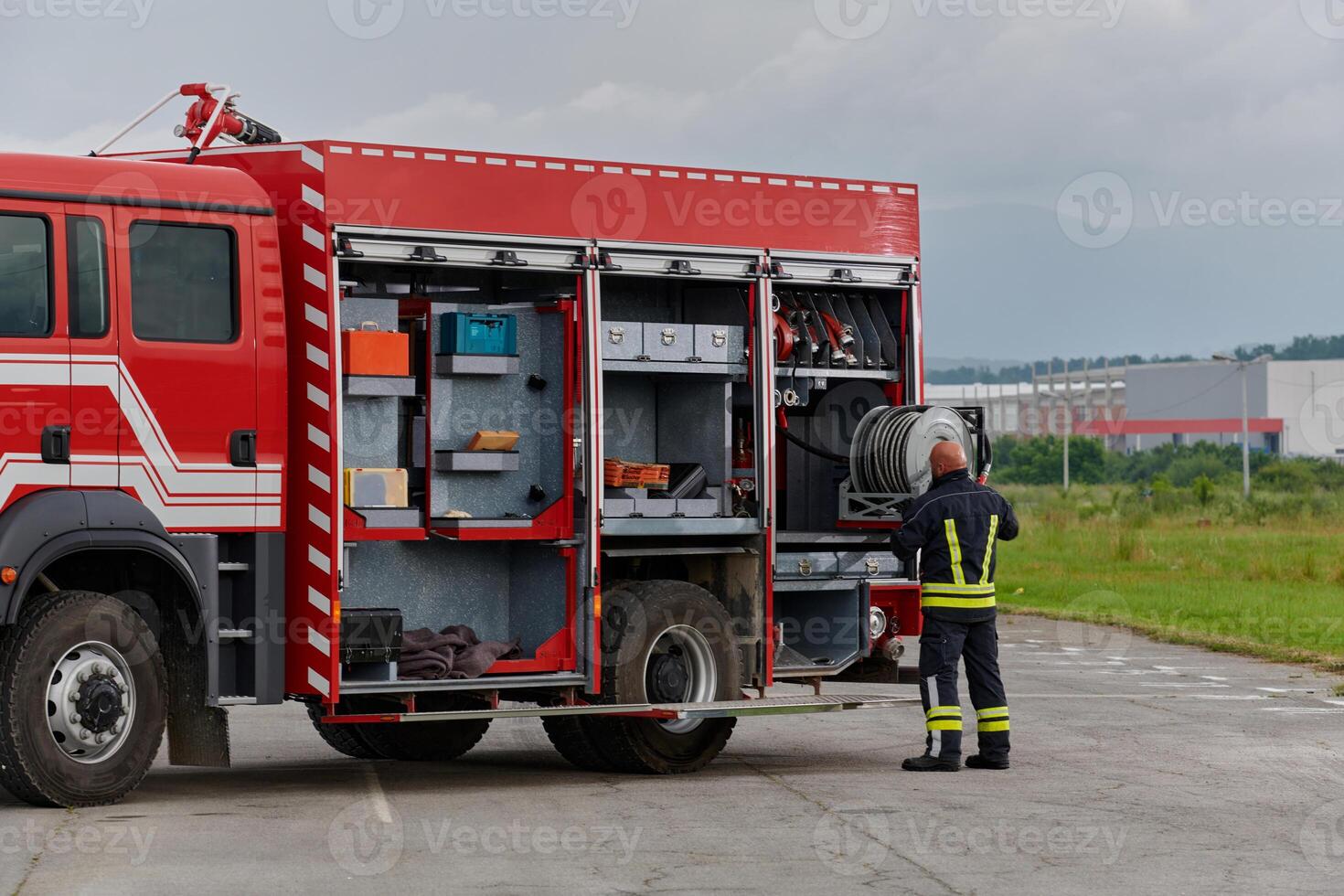 A firefighter meticulously prepares a modern firetruck for a mission to evacuate and respond to dangerous situations, showcasing the utmost dedication to safety and readiness in the face of a fire photo