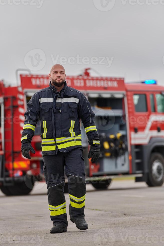 A symbolically brave firefighter strides forward with unwavering courage, epitomizing dedication and leadership, while behind him, a modern firetruck stands ready for firefighting actions, capturing photo