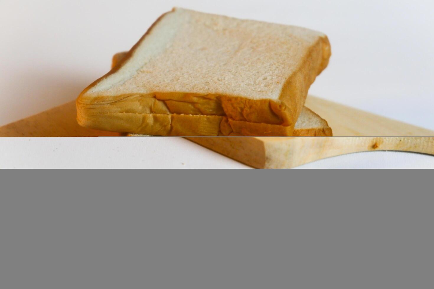 photography of bread on a wooden cutting board on a white background photo