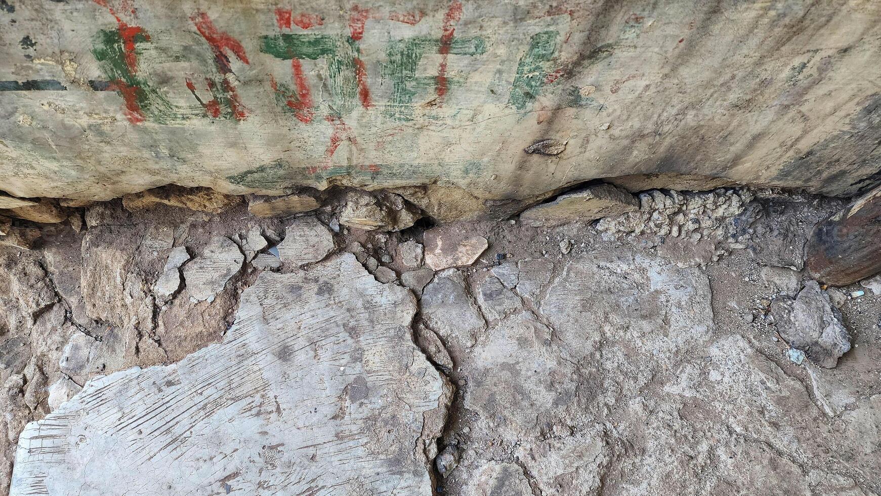 a rock with graffiti on it and a sign that says the rock photo