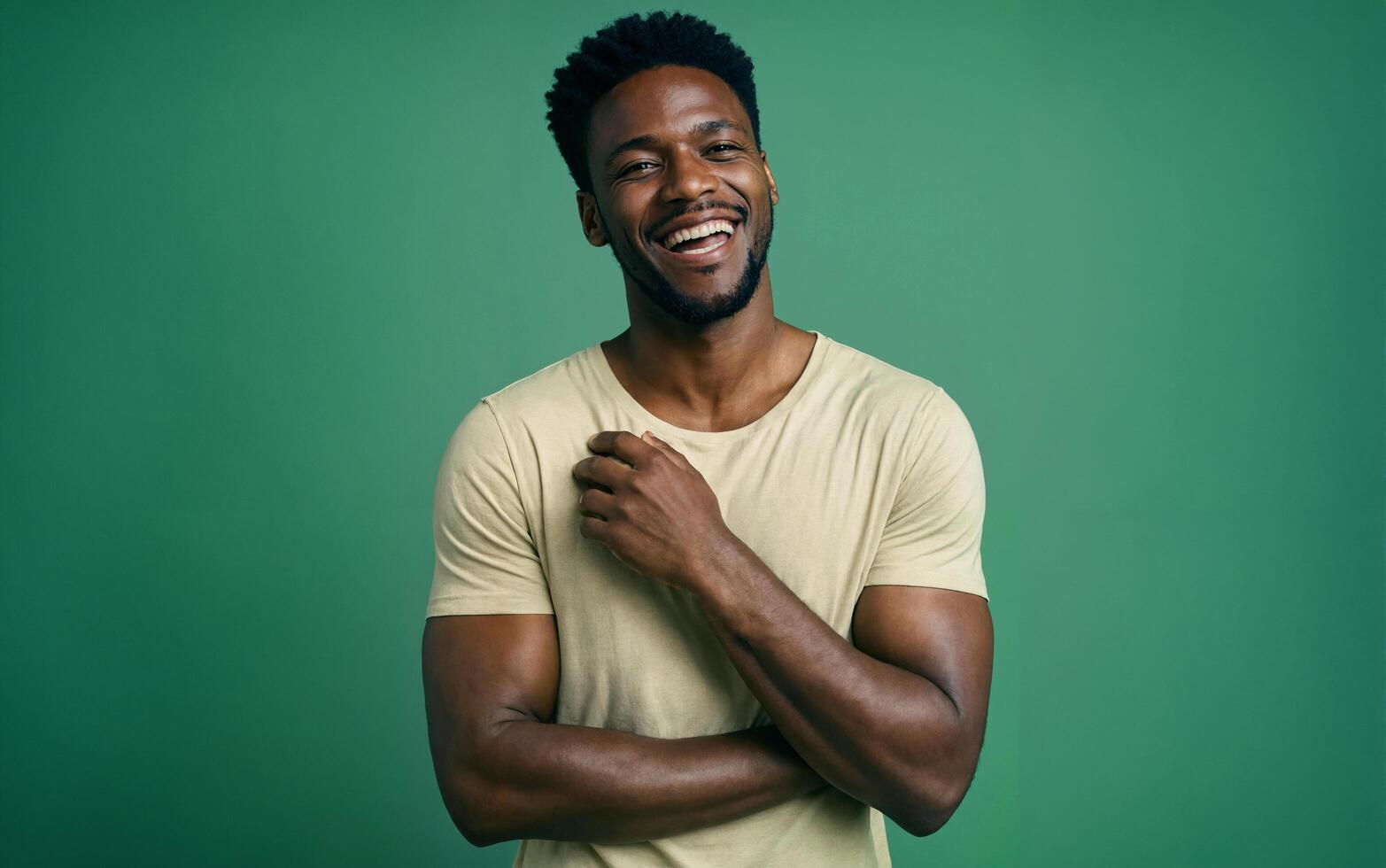 Confident African man laughing while standing against green background photo