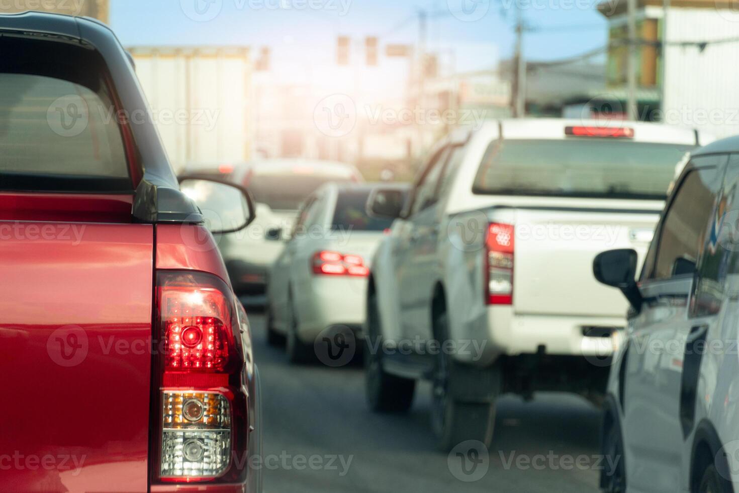 Rear side of pickup car with turn on brake light on aspahlt road. Traffic jam in the city on day time. Many cars on the road waiting in long queues to travel on business. photo