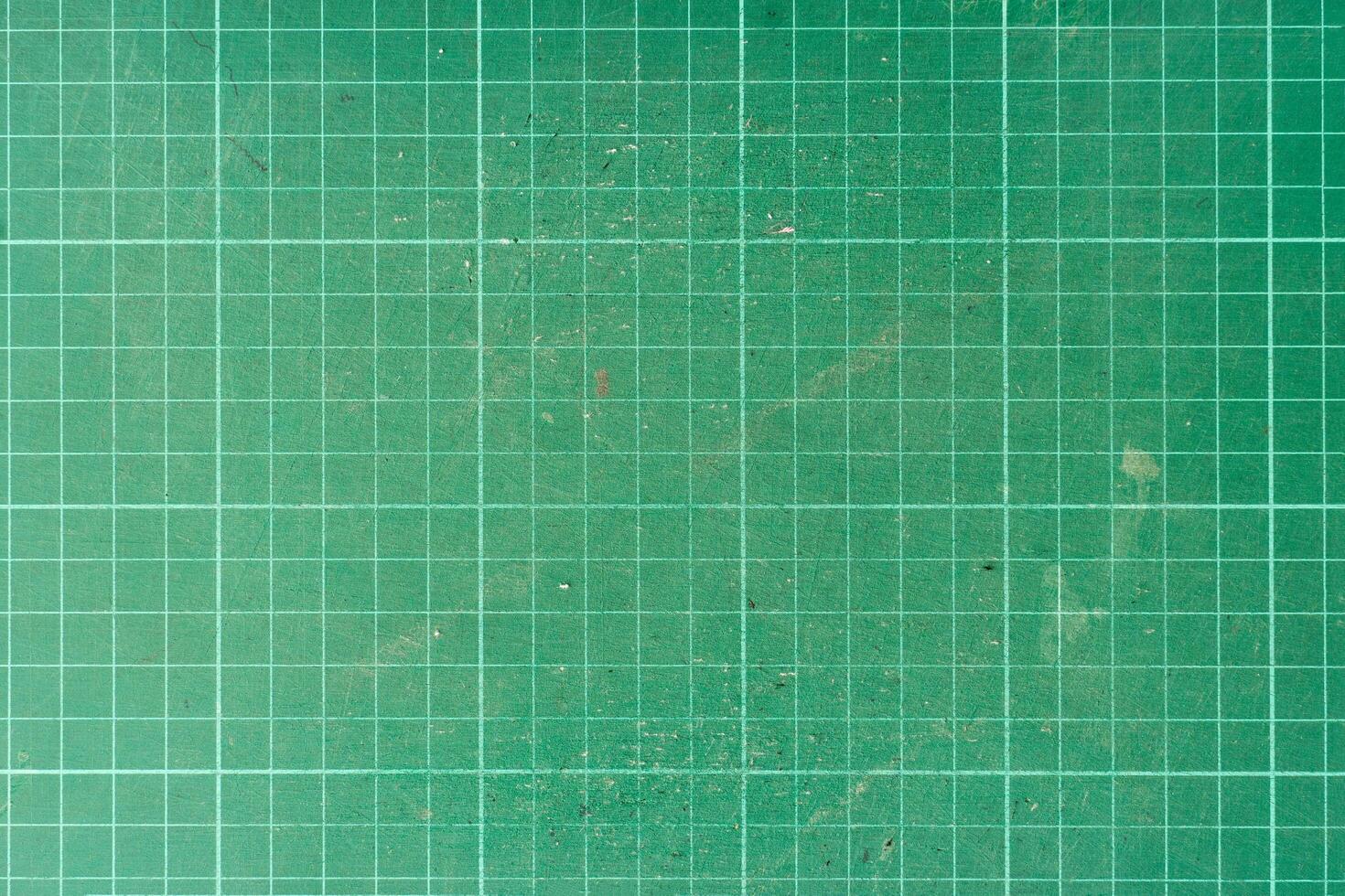 Background and textured of cutting mat green color. Used paper cutting mat. photo