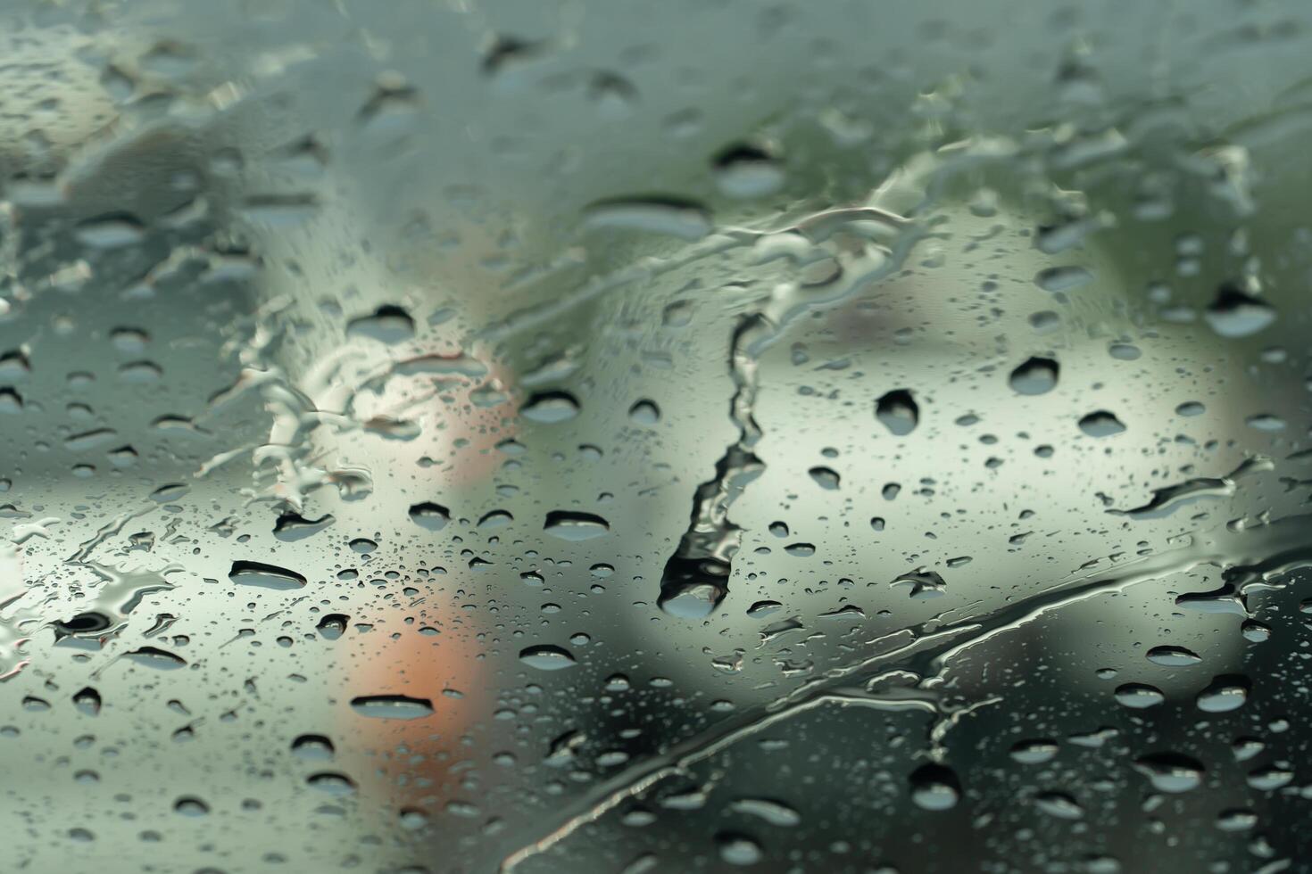 Drop of rain water on the glass of car. With blurred of other cars. photo