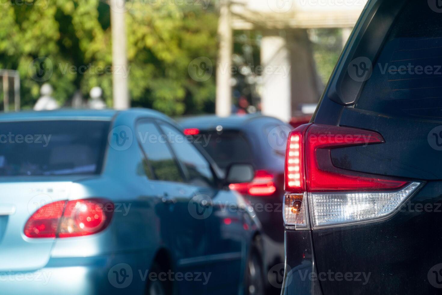 Rear side of cars on traffic jam on the roads. With turn on brake light. During time in rush hours for travel or business work in the city. with effect orange light for background. photo