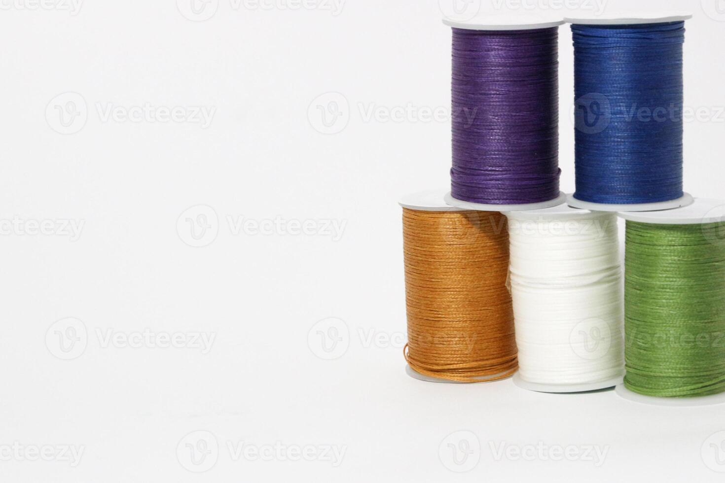 Spool of sewing thread, isolated on white background. Colored yarns used by factories in the clothing industry. Threads wound on the spool. Colored reels photo