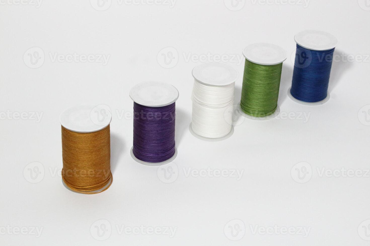 Spool of sewing thread, isolated on white background. Colored yarns used by factories in the clothing industry. Threads wound on the spool. Colored reels photo