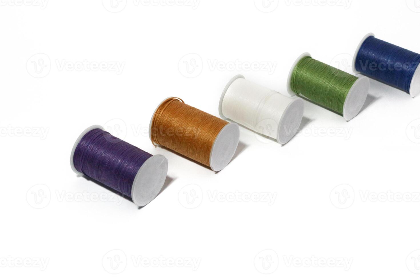 Spool of sewing thread, isolated on white background. Colored yarns used by factories in the clothing industry. Threads wound on the spool. Colored reels photo