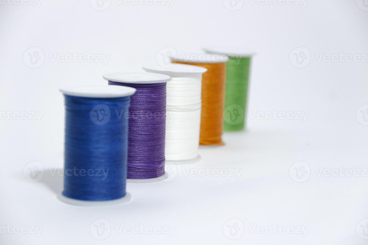 Spool of sewing thread, isolated on white background. Colored yarns used by factories in the clothing industry. Threads wound on the spool. Colored reels photo