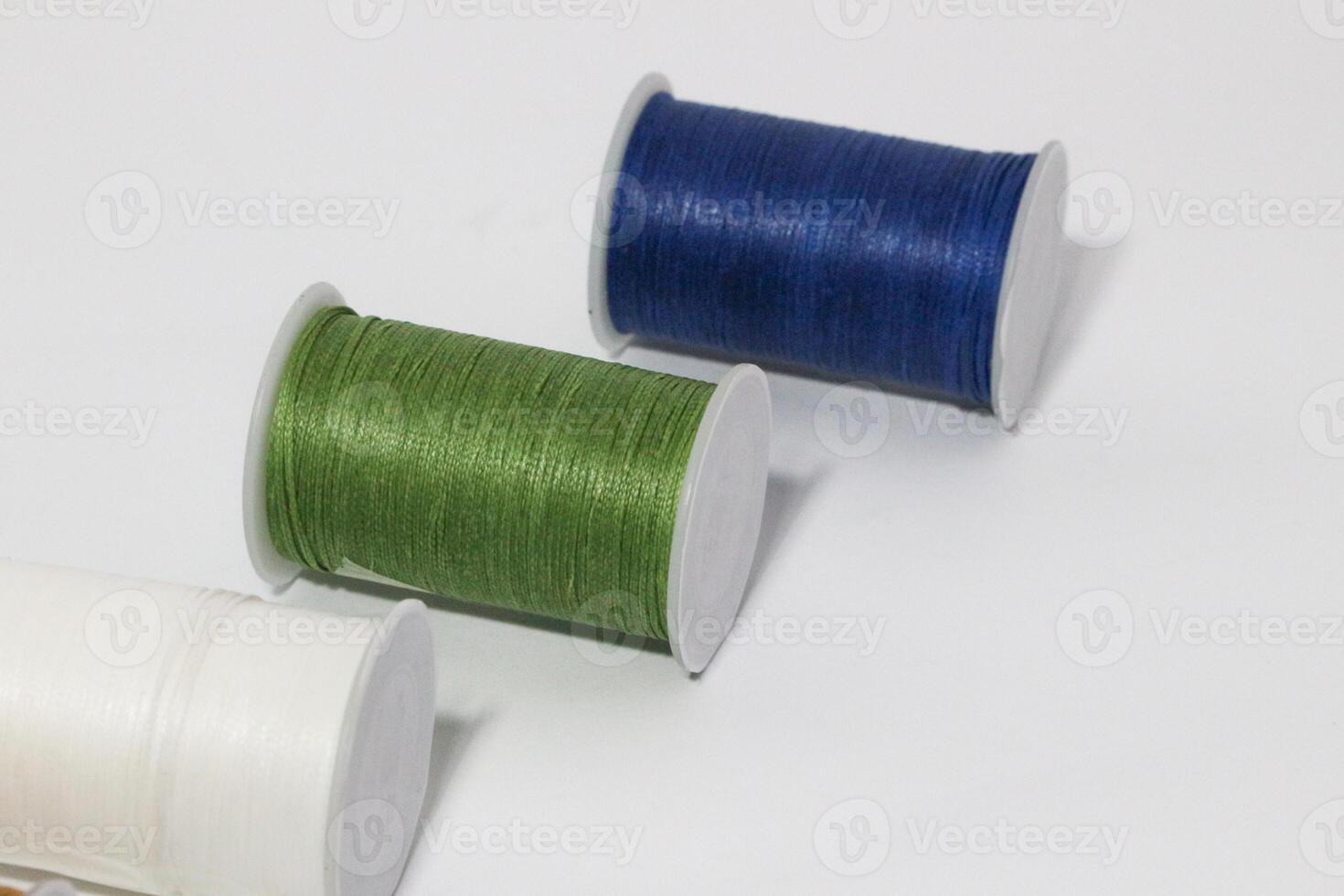 Spool of sewing thread, isolated on white background. Colored yarns used by factories in the clothing industry. Threads wound on the spool. Colored reels photo