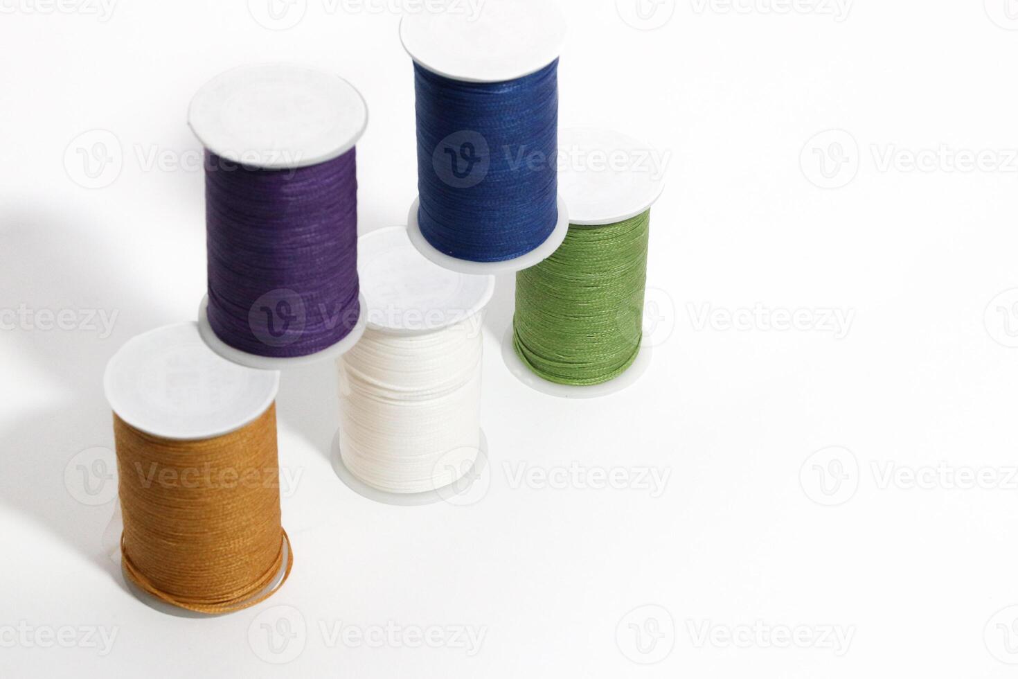 Spool of sewing thread, isolated on white background. Colored yarns used by factories in the clothing industry. Threads wound on the spool. Colored reels photo