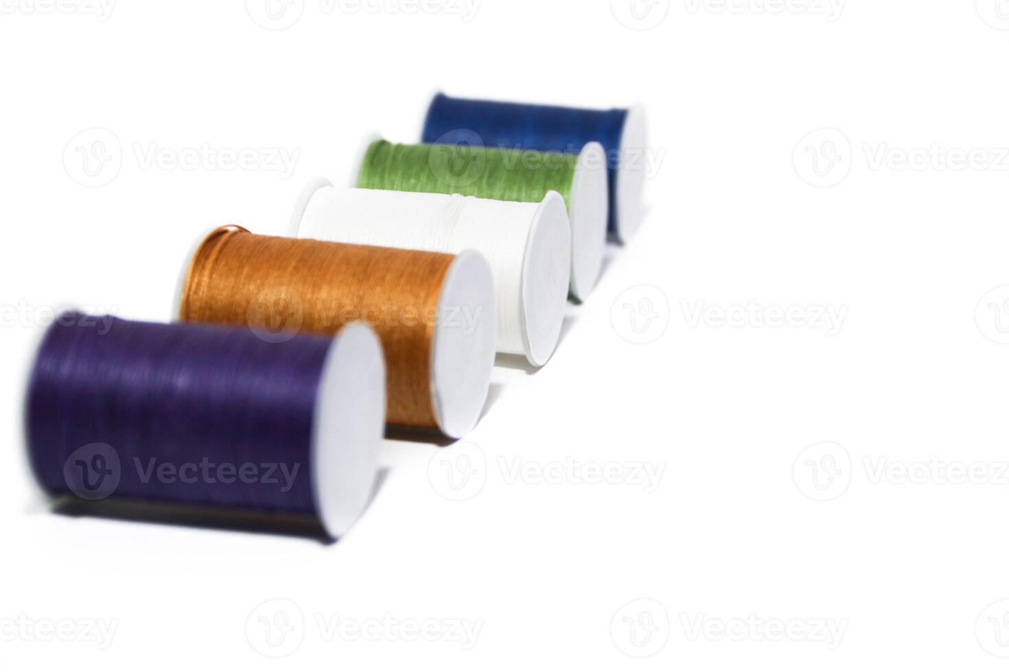 Spool of sewing thread, isolated on white background. Colored yarns used by factories in the clothing industry. Threads wound on the spool. Colored reels photo