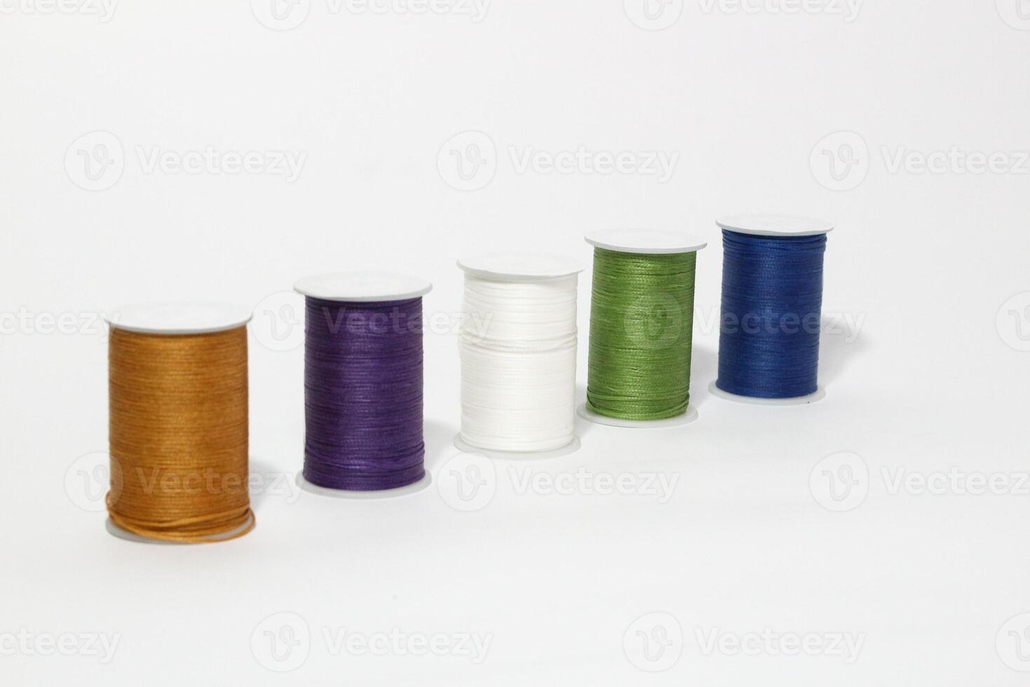 Spool of sewing thread, isolated on white background. Colored yarns used by factories in the clothing industry. Threads wound on the spool. Colored reels photo