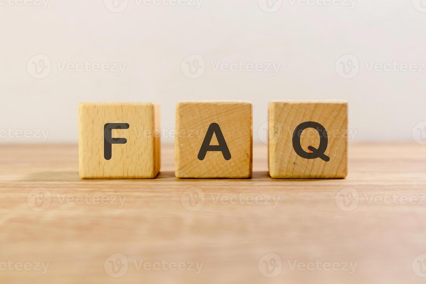 Frequently asked questions or FAQ written on wooden blocks photo
