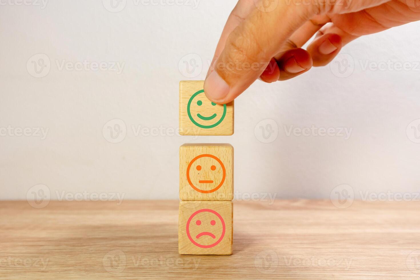 Hand picked the happy face emoticon on wooden blocks. Customer review satisfaction feedback concept. photo