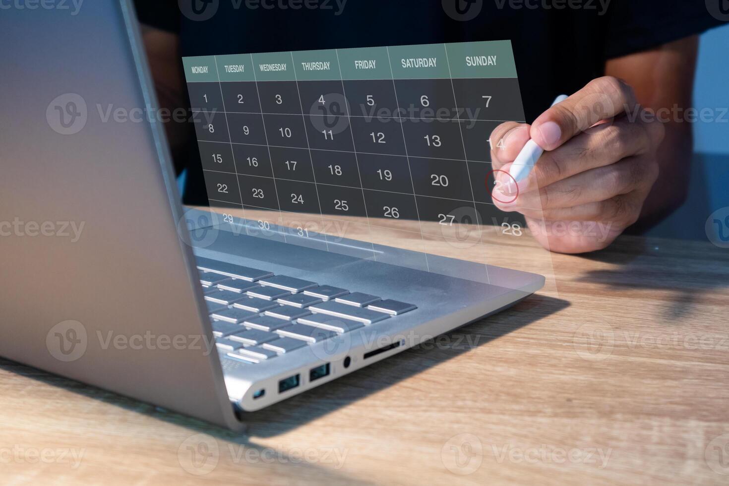 A calendar on the virtual screen. A man manages time for an effective schedule. photo