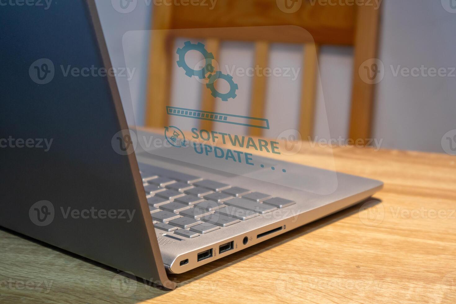 Software system update process concept. A laptop on the table with updating progress bar on virtual screen. photo