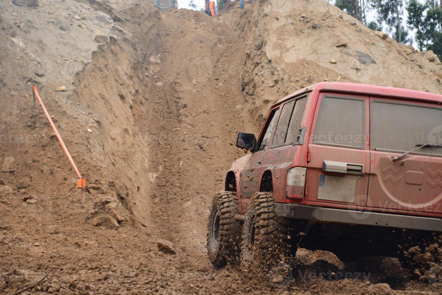 a red SUV in the mud accelerates to overcome obstacles. Off-road competition for SUVs. photo