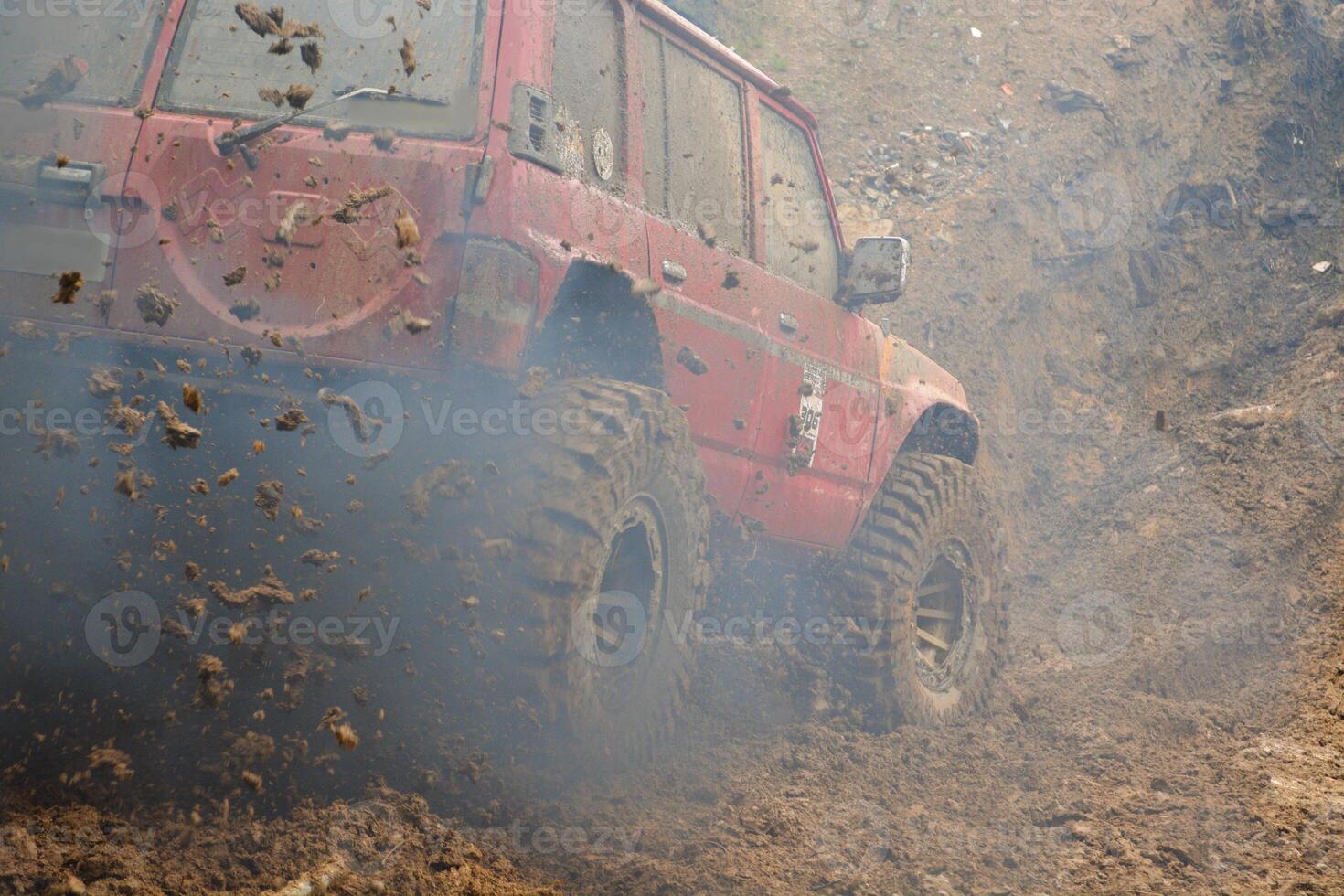 a red SUV in the mud accelerates to overcome obstacles Off road