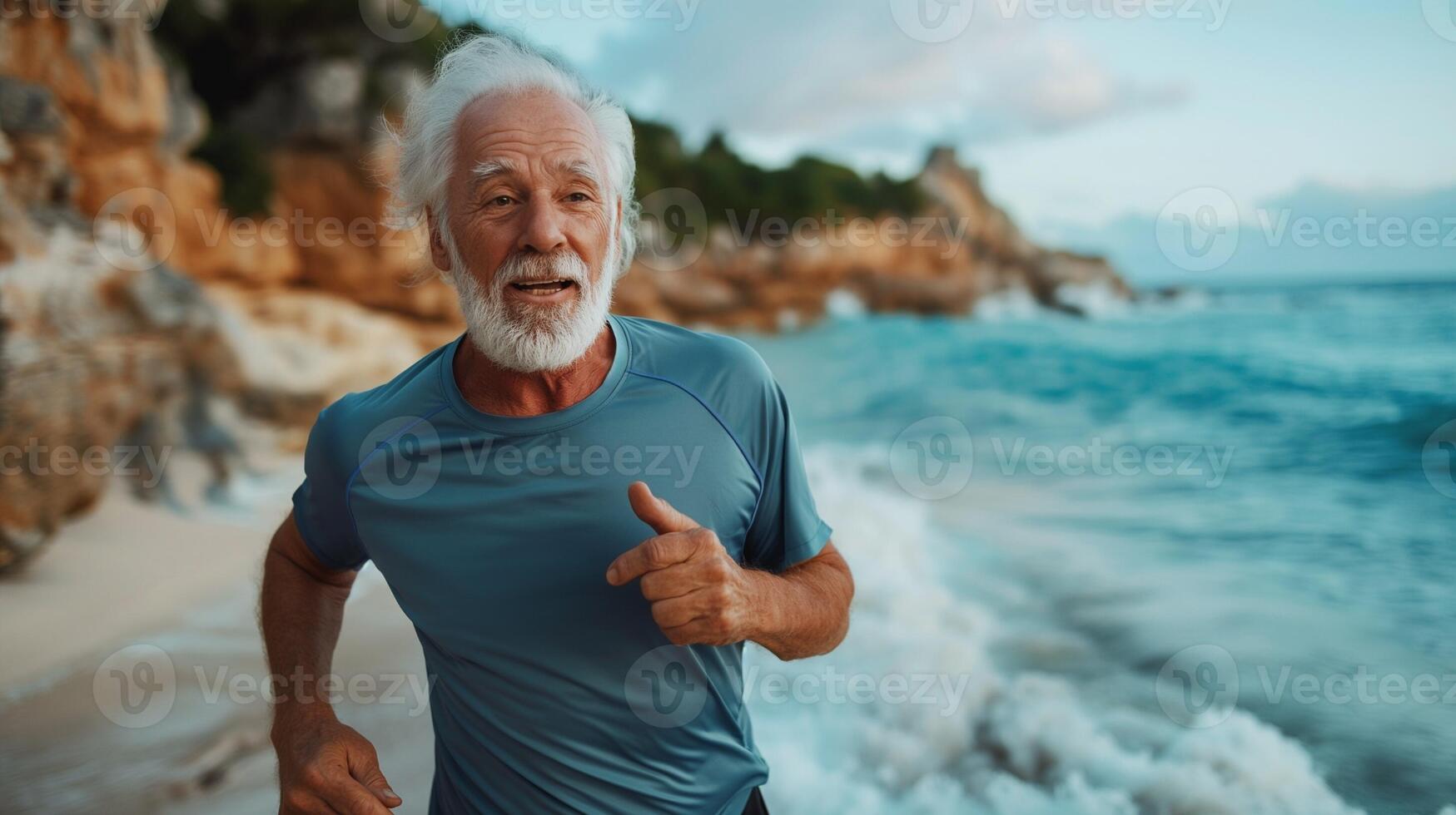 An elderly man with gray hair, 60, with a pumped up handsome body, is jogging on the ocean shore. Healthy lifestyle and happy old age by the sea photo