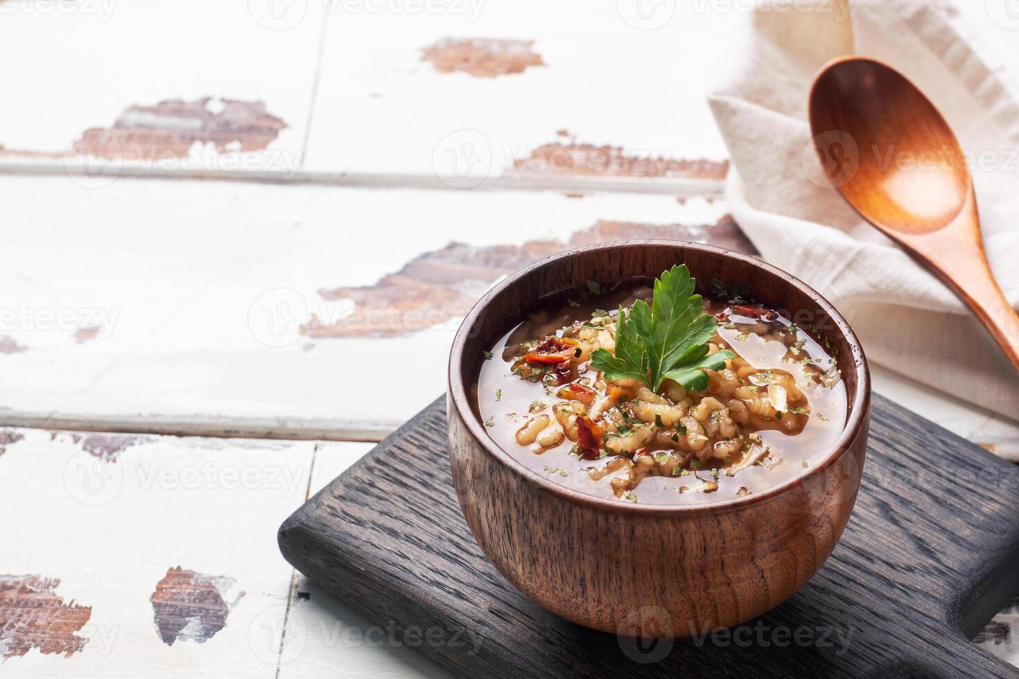 Vegetarian soup kharcho with rice and vegetables. Garlic hot pepper tomatoes. Copy space. Wooden rustic background, plates made of natural bamboo. photo