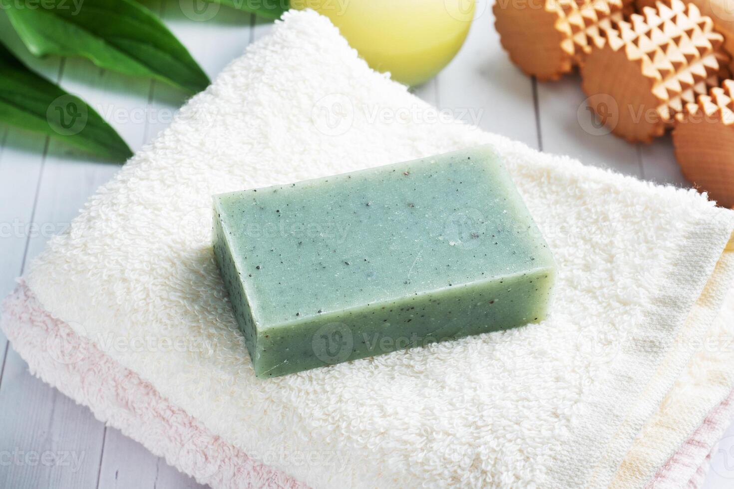 Concept SPA and Wellness. Massage brush, cosmetic oils and soap. Light background with green leaf. photo