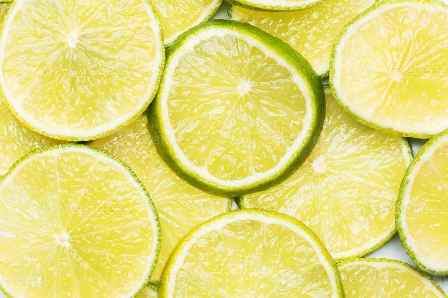 Slices of ripe juicy lime. Green background of citrus lime. photo