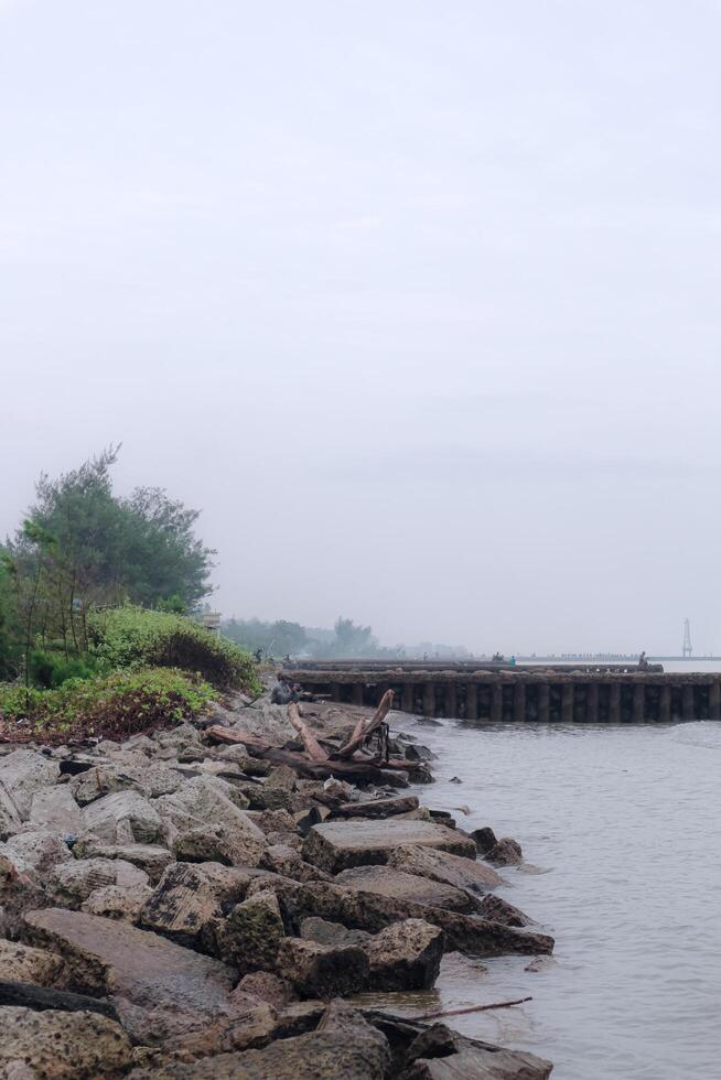 widuri beach coastal area pemalang with wave-crushing rocks photo