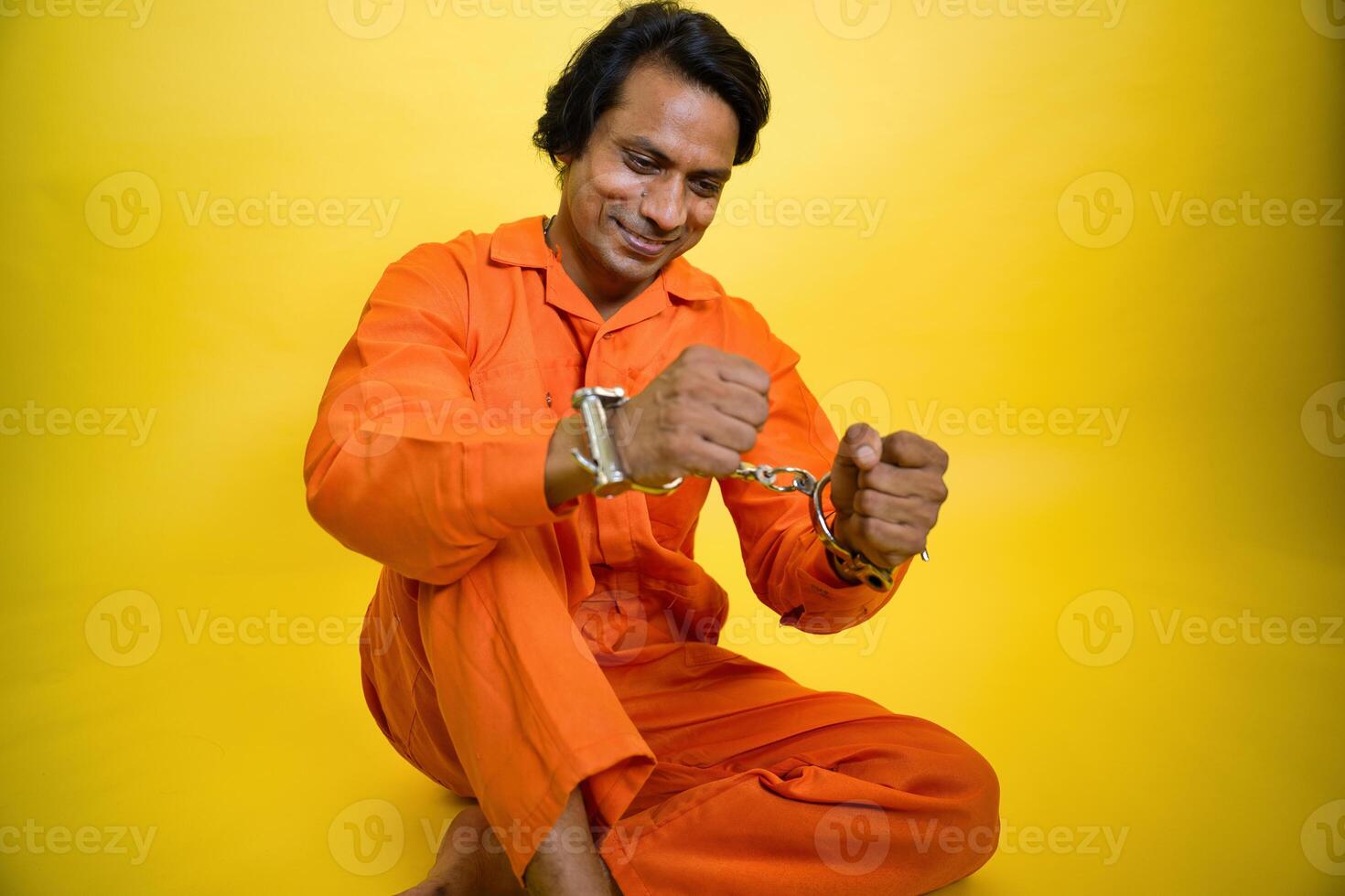 Smiling prisoner man breaking handcuff photo