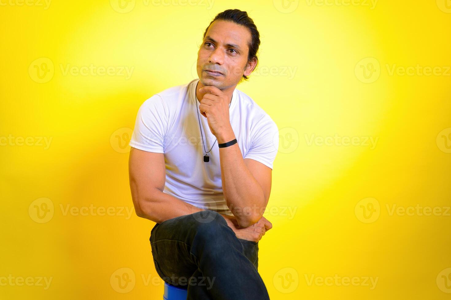 Thoughtful man daydreaming sitting on stool photo