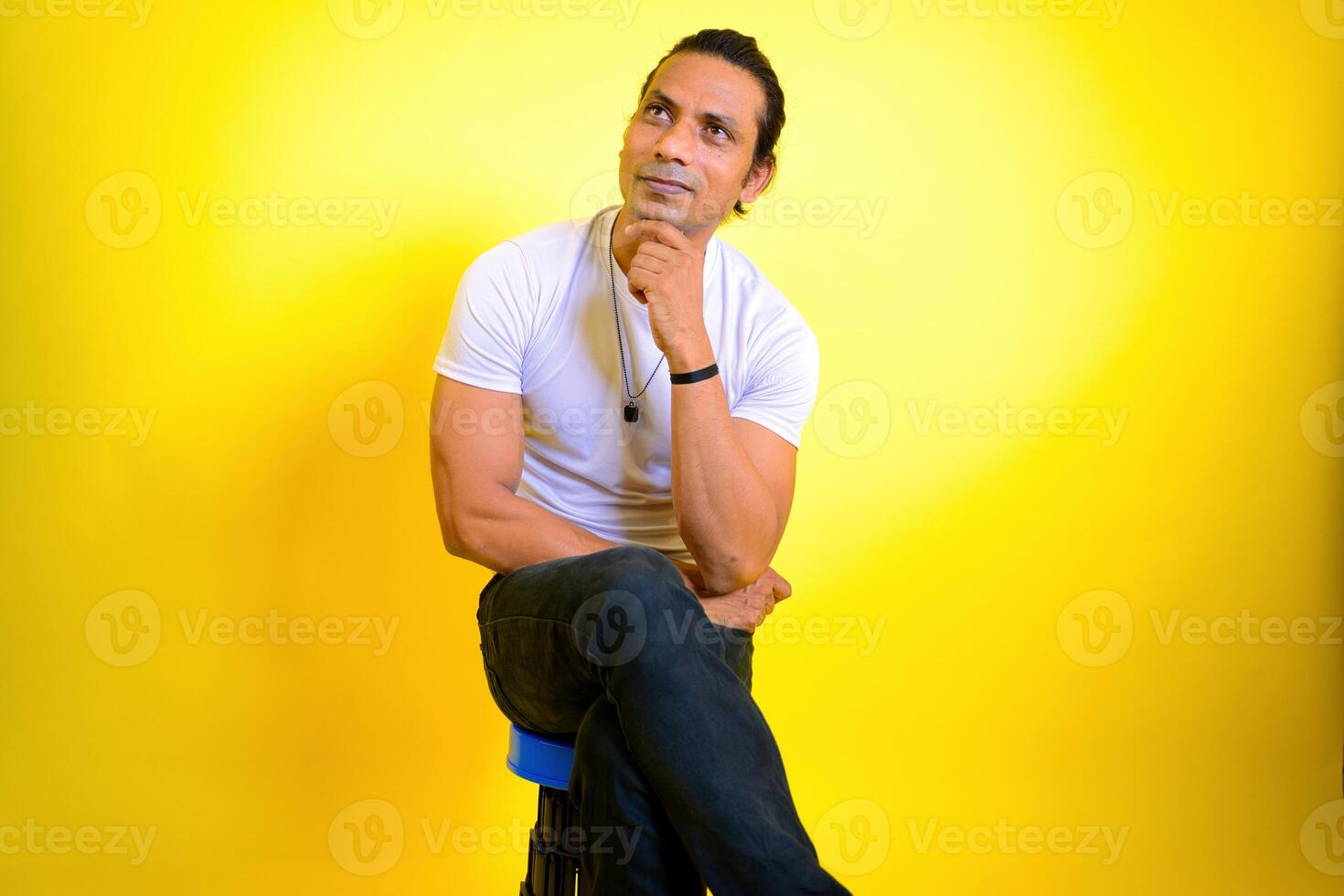 Thoughtful man daydreaming sitting on stool photo