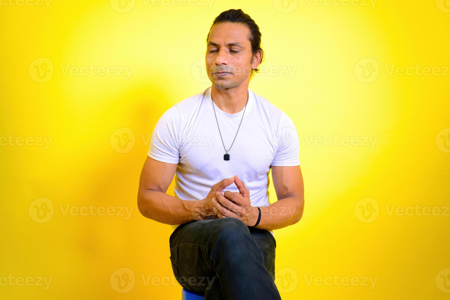 Man meditating on stool photo