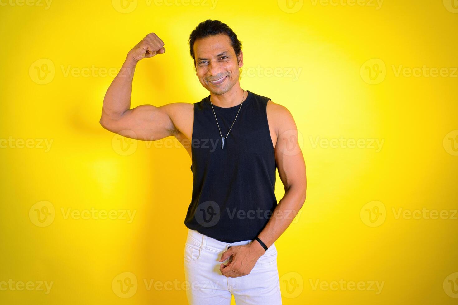 Man in black tank top flexing muscles photo