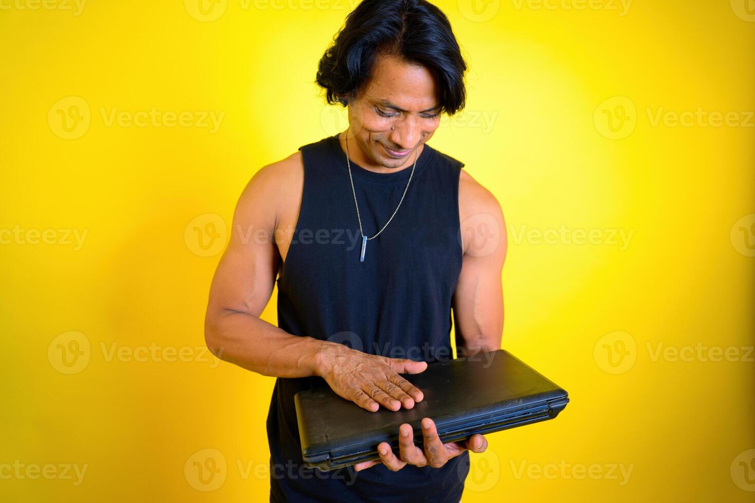 Smiling man holding a laptop with emotion photo