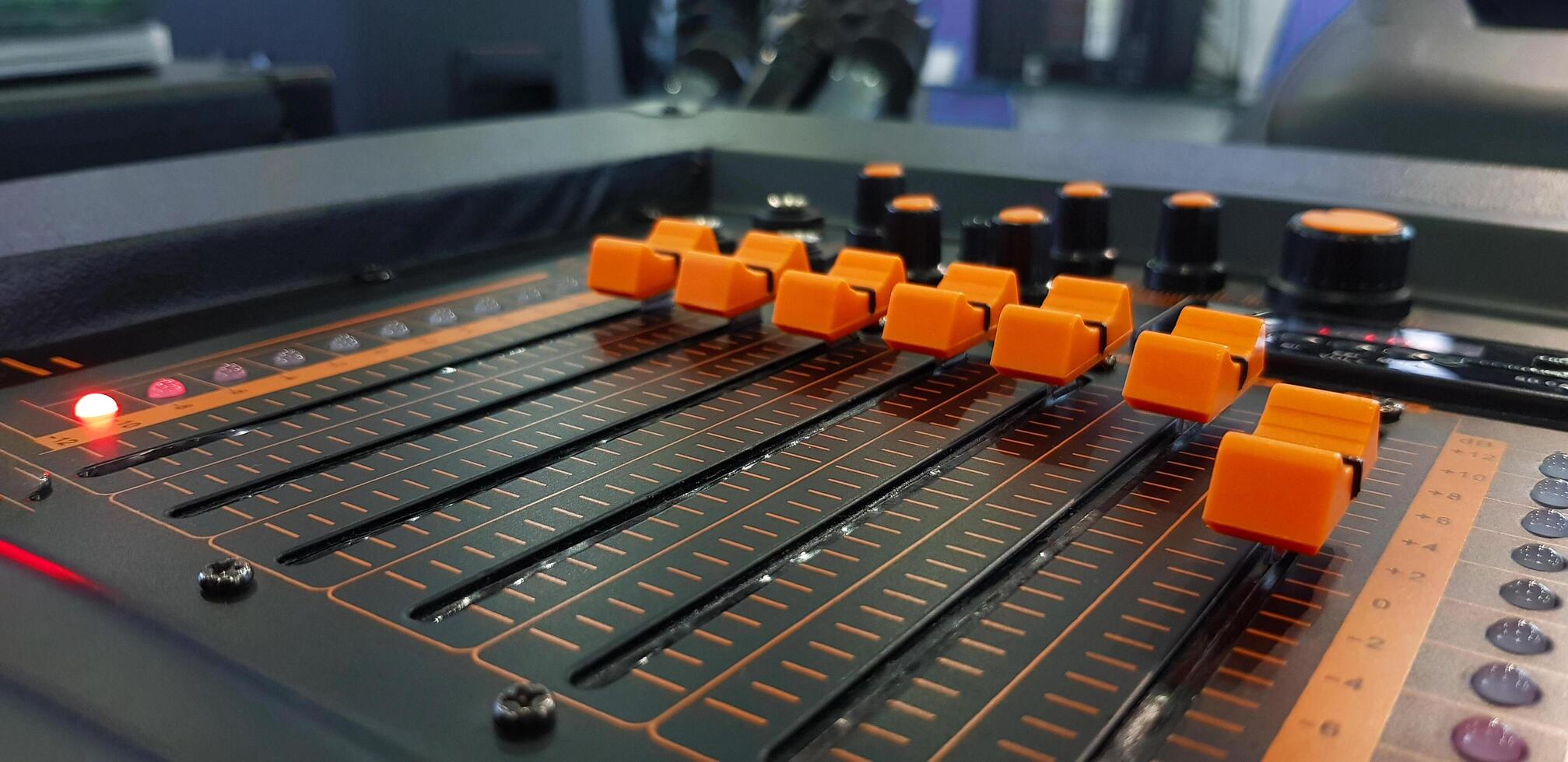 Close up orange button of sound mixer panel equipment for mixing or control audio system with selective focus technique. Technology, Tool and Digital device concept. photo