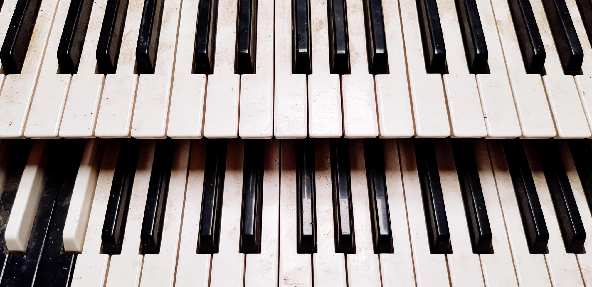 Close up pattern of old or dirty piano keyboard for background. Object, Art, Music and Instrument concept. photo