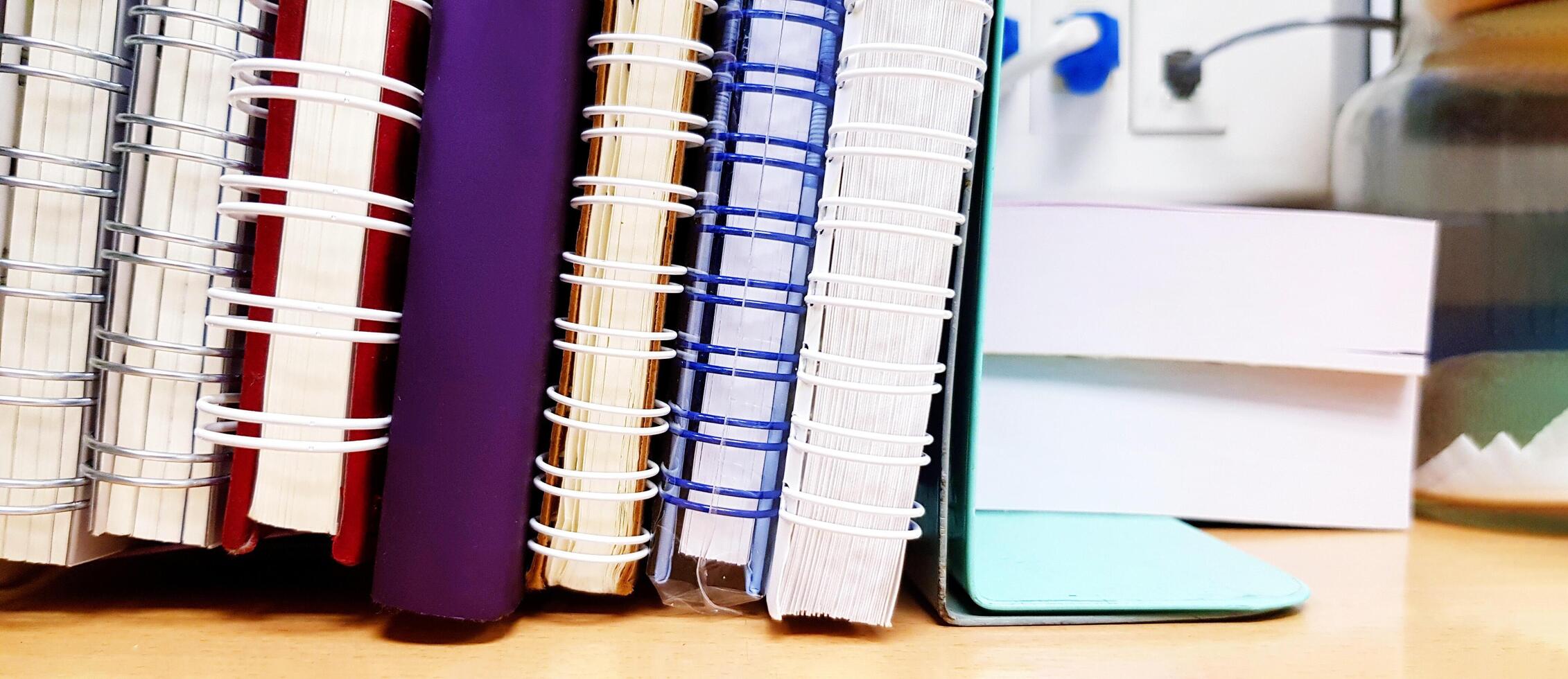 Close up many book is placed or putting on a wooden table at office or school. Education, Office tool and object concept. photo