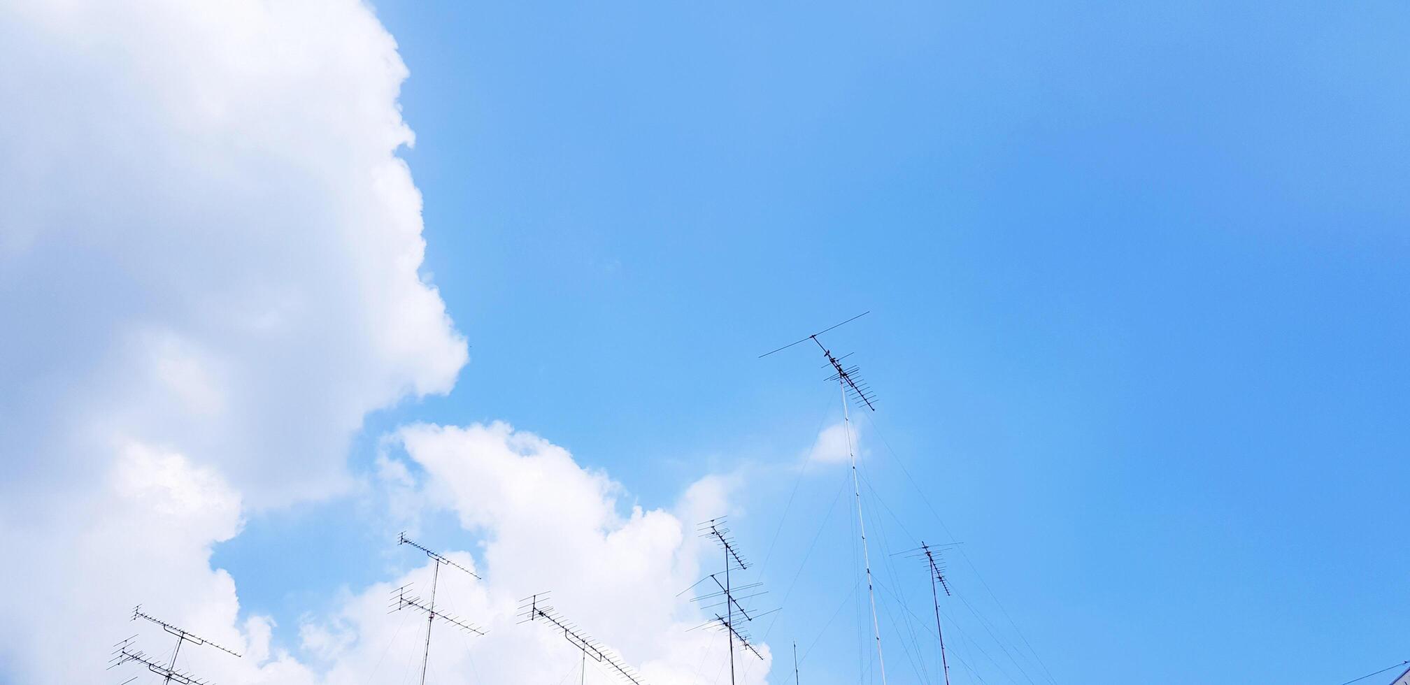 Many TV or Television antenna on the blue sky and white clouds with above copy space. Technology, Beauty of Nature and Communication concept. photo