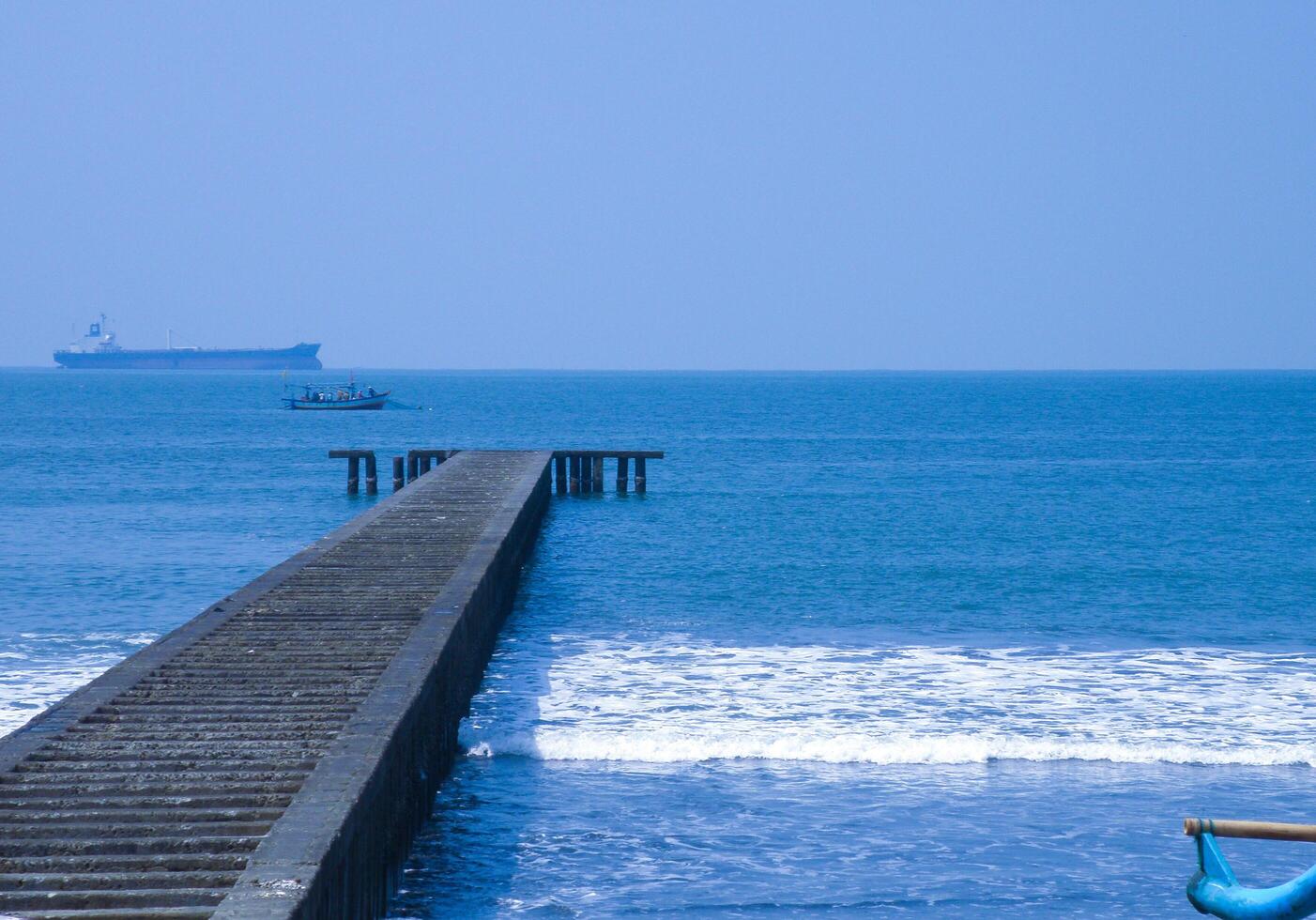 Serene Ocean Pier with Distant Ships photo