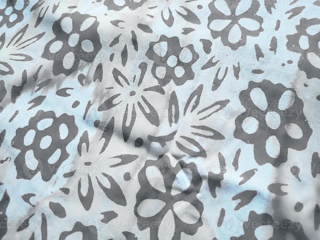 The fabric is patterned with a dense arrangement of blooming floral motifs in medium tones photo