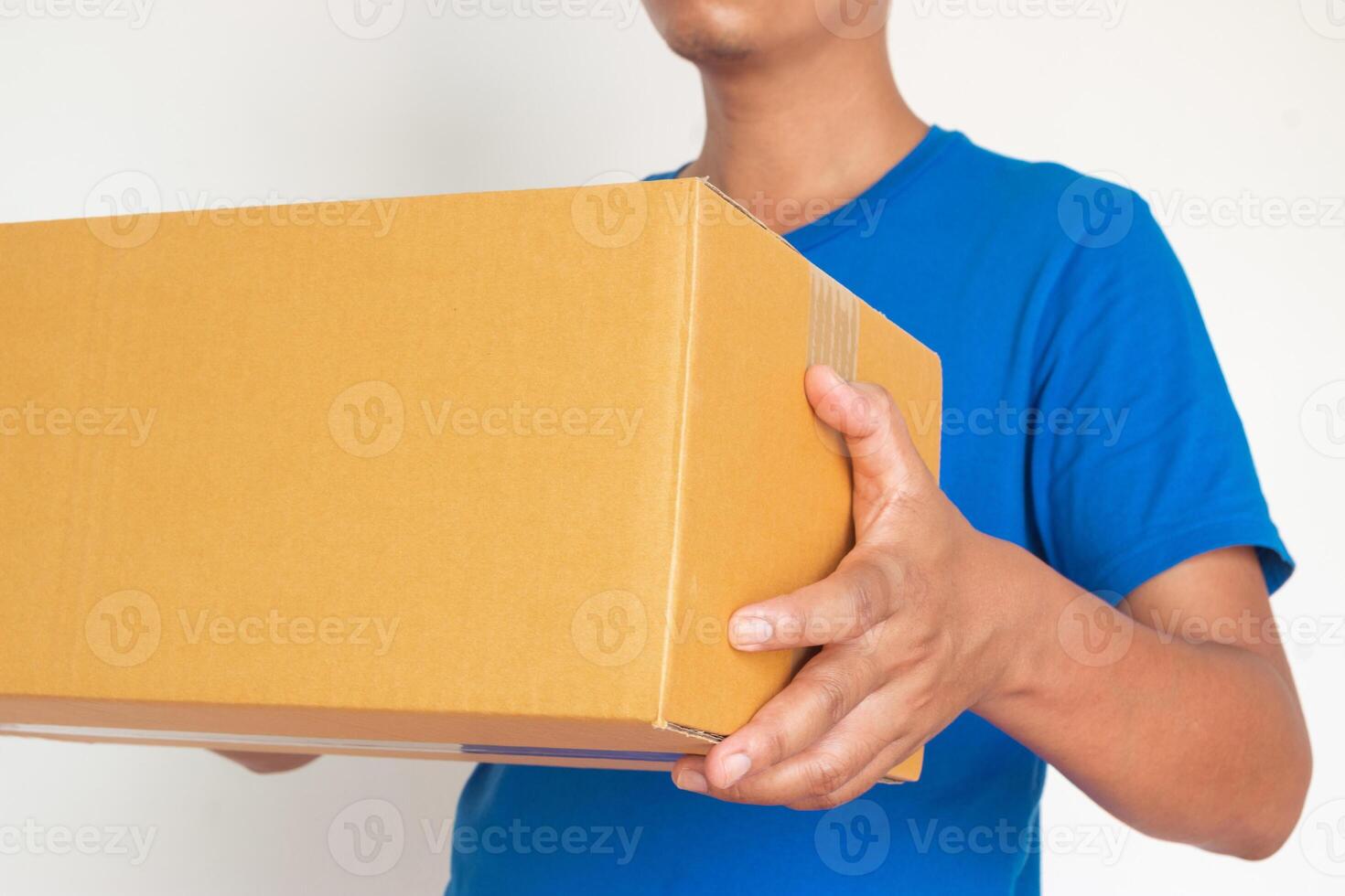 Closeup hands of delivery man holding package to deliver. Courier hand holding brown box isolated on white background. photo